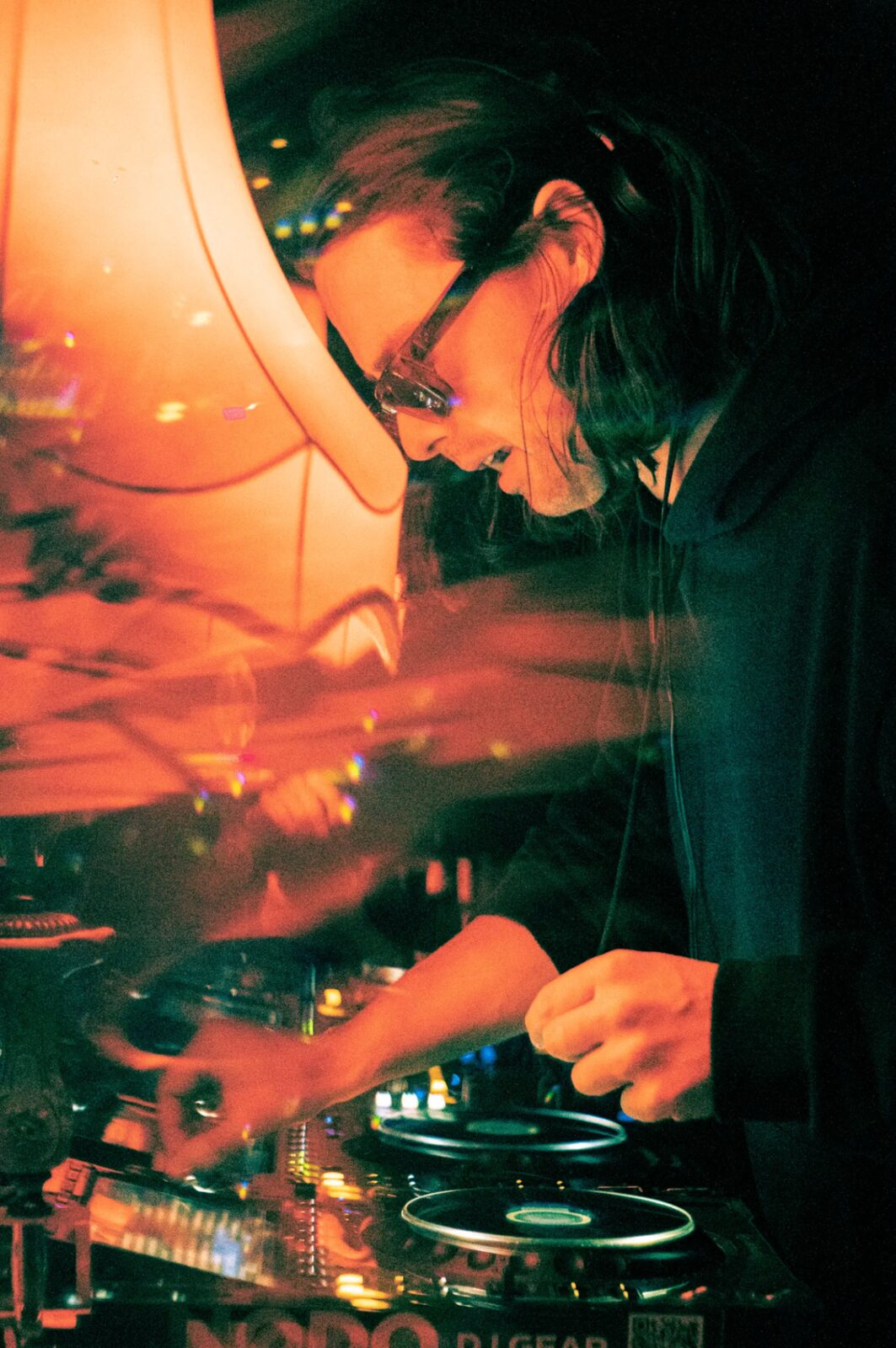 Artist behind decks, amber light